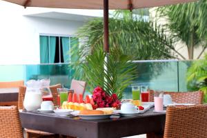 een tafel met een ontbijt van fruit en melk bij Star Hotel in Jericoacoara