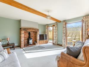 a living room with a couch and a fireplace at The Farm House in Shipton under Wychwood