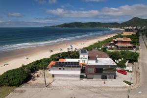 eine Luftansicht auf einen Strand mit einem Gebäude in der Unterkunft Apartamento Frente Mar Vista Lateral in Bombinhas