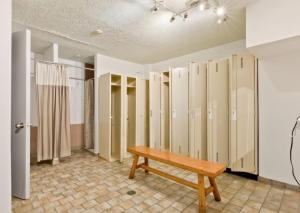 a room with a wooden bench and some closets at Magog Waterfront Studio 106 in Magog-Orford