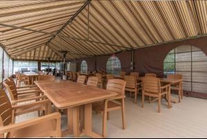 a large tent with wooden tables and chairs at Magog Waterfront Studio 106 in Magog-Orford