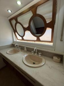 baño con 2 lavabos y espejo grande en Casa Chakana en San Rafael