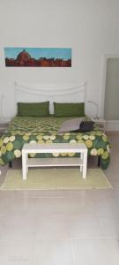 un letto con panca in una stanza di Villa Scavuzzo a Realmonte