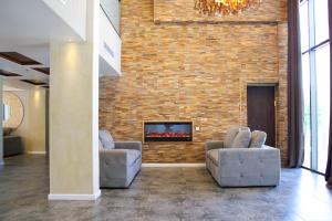 a living room with two couches and a brick wall at Yarden Estate Boutique Hotel in Yesod Hamaala