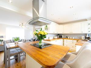a kitchen with a wooden table with yellow flowers on it at Craig Y Nos in Saundersfoot