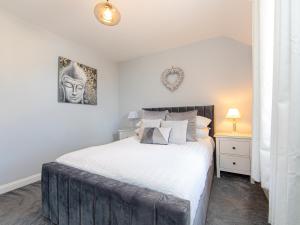 a bedroom with a large bed with white sheets at Craig Y Nos in Saundersfoot