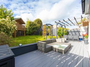 a deck with a bench and a pergola at Craig Y Nos in Saundersfoot