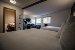 a bedroom with a large white bed and a desk at Bedrock Motel in Mayo Landing