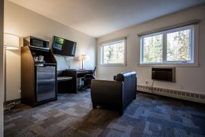 a hotel room with a chair and a desk at Bedrock Motel in Mayo Landing