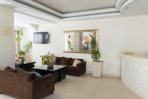 ein Wohnzimmer mit zwei Sofas und einem Fernseher in der Unterkunft Zante Plaza Hotel & Apartments in Laganas
