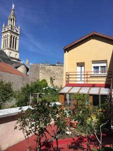 un bâtiment avec une tour d'horloge en arrière-plan dans l'établissement Un moment de douceur, à Nancy