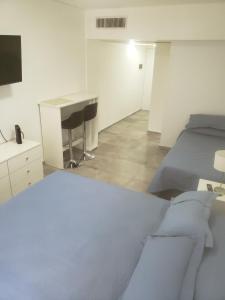 Habitación blanca con cama, escritorio y escritorio. en Av. Corrientes 818 - Ciudad de Buenos Aires - en Buenos Aires