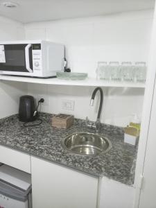 encimera de cocina con fregadero y microondas en Av. Corrientes 818 - Ciudad de Buenos Aires - en Buenos Aires