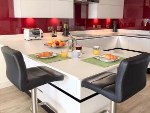 a kitchen with a table with fruit on it at Stylish Sea View Apartment with Parking in Penzance