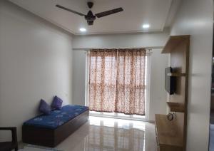 - un salon avec un canapé bleu en face d'une fenêtre dans l'établissement Shiv- Vatsalya Homestay, à Nashik