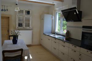 a kitchen with a table and a white refrigerator at Märchenherberge 7 Zwerge in Lichtenau