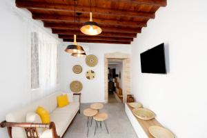 a living room with a white couch and wooden ceilings at Pera houses 2-bedroom in the center of Lindos in Líndos