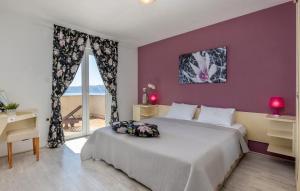a bedroom with a large bed with a purple wall at E&M in Senj