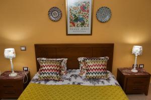una camera da letto con un letto con due lampade e una foto a parete di DESiGN UNQUE appartement a Sousse