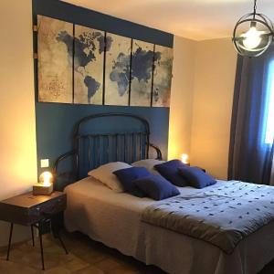 1 dormitorio con 1 cama grande y una pintura en la pared en L’Antre d’Eux, en Carcassonne