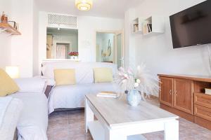 a living room with a couch and a tv at Casa Playa Bonita Primera linea de playa in Roquetas de Mar