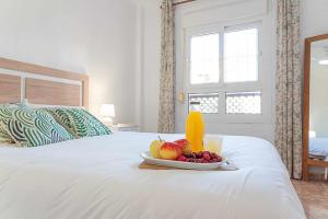 a plate of fruit and a glass of orange juice on a bed at Casa Playa Bonita Primera linea de playa in Roquetas de Mar +40 photos