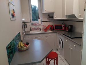 a kitchen with a table with a bowl of fruit on it at Appartement Perros-Guirec, 3 pièces, 4 personnes - FR-1-368-167 in Perros-Guirec