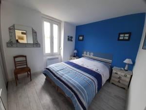 um quarto azul com uma cama e uma cadeira em Appartement Perros-Guirec, 3 pièces, 4 personnes - FR-1-368-167 em Perros-Guirec