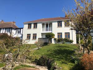 a large white house with a yard at 3 Bed Ground Floor Apartment - Hot Tub Optional Upgrade in Hythe