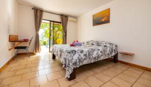 Schlafzimmer mit einem Bett und einem Tisch in der Unterkunft Pension Mave Mai in Nuku Hiva