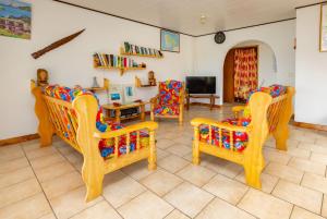 ein Wohnzimmer mit 2 Stühlen und einem TV in der Unterkunft Pension Mave Mai in Nuku Hiva