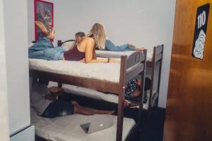 grupa osób kładących się na łóżkach piętrowych w obiekcie Hostel Playa Grande Güemes w mieście Mar del Plata