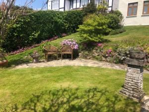 a garden with a table and chairs and flowers at 3 Bed Ground Floor Apartment - Hot Tub Optional in Hythe