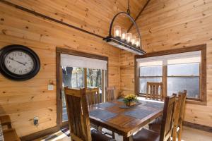 a dining room with a table and a clock on the wall at 1 Kingfisher in Blowing Rock +36 photos