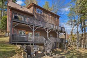 a large wooden house with a deck and chairs at 1 Kingfisher in Blowing Rock
