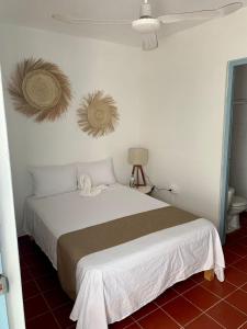 a bedroom with a white bed with a brown blanket at Creta Hotel & Suites in Mazatlán
