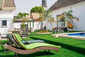 a backyard with lawn chairs and a swimming pool at Alder studio Apt+Gym+Snooker board. Rhodabode Nile in Abuja