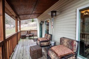 a porch with chairs and tables on a house at 1eight3 Retreat in Blowing Rock