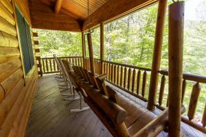 a row of chairs on a porch of a cabin at A Beary Good Time in Boone