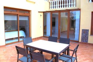einen Tisch und Stühle auf einer Terrasse mit einem Schlafzimmer in der Unterkunft Finca La Punta in Icod de los Vinos