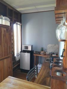 a kitchen with a table with a microwave and a stove at Bungalow Batsù in Fortuna