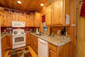 a kitchen with wooden cabinets and a white stove top oven at A Rustic Hideaway in Todd
