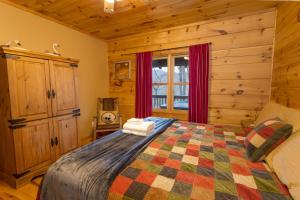 a bedroom with a bed in a log cabin at A Rustic Hideaway in Todd