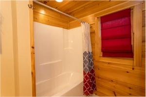 a bathroom with a tub and a shower curtain at A Rustic Hideaway in Todd +15 photos