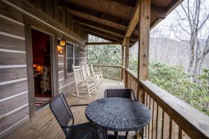 a table and chairs on a porch of a cabin at A Rustic Hideaway in Todd