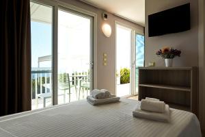 1 dormitorio con 1 cama y balcón con TV en I Vereti, en Patù