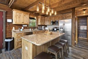 a kitchen with wooden cabinets and a large island with bar stools at Almost Heaven in Boone