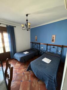 Habitación con 2 camas y pared azul en Casa Kini, en Cazalla de la Sierra