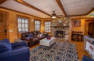 a living room with a couch and a stone fireplace at Appalachian Escape in Blowing Rock