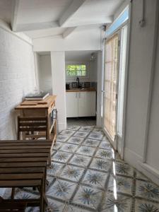 a hallway with a table and benches and a kitchen at Fieldside Studio Flat in Hendon